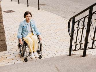 person on wheelchair in front of stairs